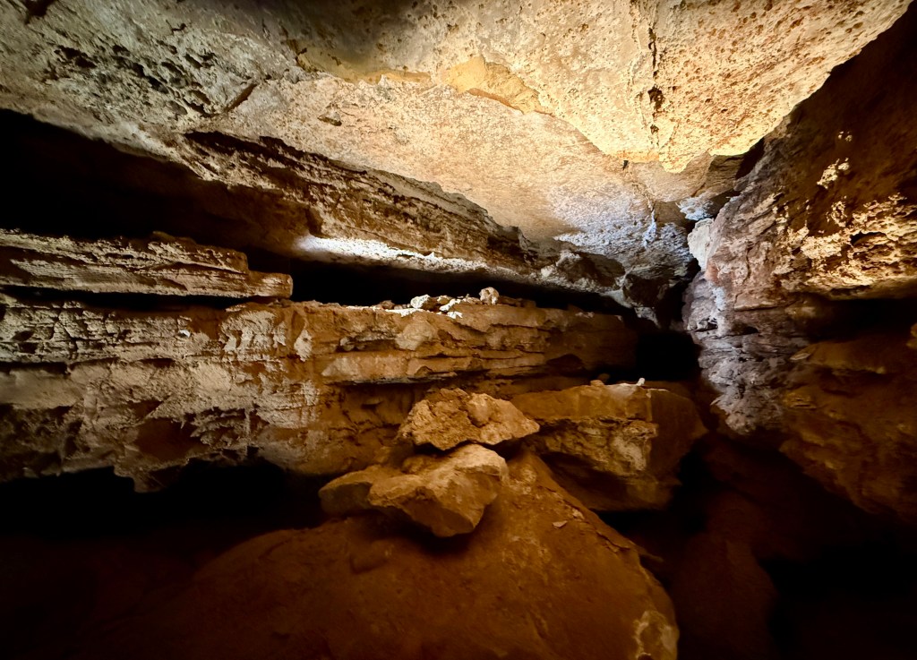 An interior view of Wind Cave displaying rock formations and natural lighting from above.