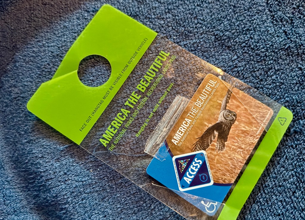 America the Beautiful pass displayed on a textured blue background, featuring an owl and an access symbol.