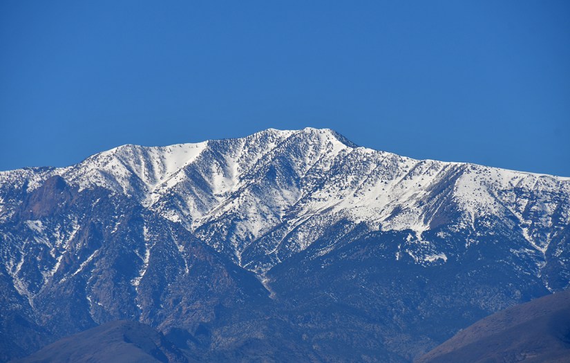 Snow-covered mountain peaks against a clear blue sky.