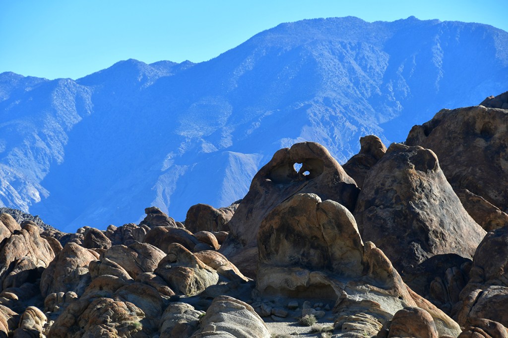 Scenic view of a rugged mountain landscape with distinctive rock formations, featuring a heart-shaped rock among the peaks.