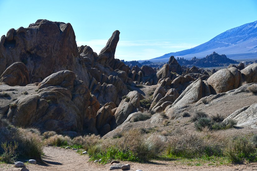 A rocky landscape featuring large boulders and rugged terrain under a clear blue sky.