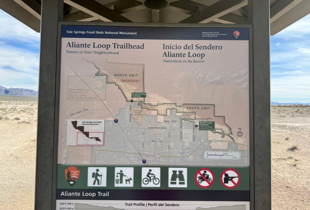 Informational sign at the Aliante Loop Trailhead, detailing trail paths and areas of the Tule Springs Fossil Beds National Monument, with maps indicating the North and South Units.