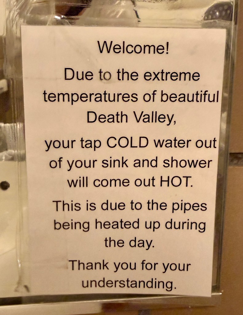 Sign explaining that due to high temperatures in Death Valley, cold water from sinks and showers may come out hot.