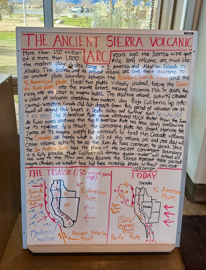 A whiteboard displaying information about the Ancient Sierra Volcanic Arc, including diagrams of tectonic plate movements and volcanic activity over 250 million years, along with notes on the Juan de Fuca and North American plates.