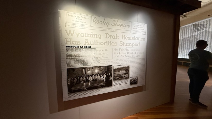 A historic newspaper display featuring the headline 'Wyoming Draft Resistance Has Authorities Stumped' with a photo collage below, showcasing people involved in the draft resistance movement.