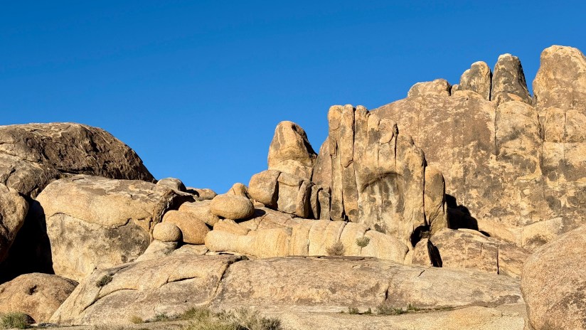 Large rock formations resembling a hand, set against a clear blue sky.