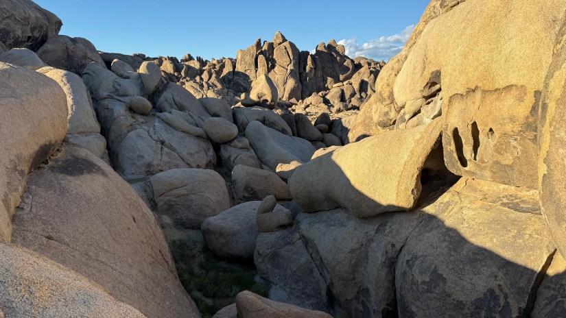 A rocky landscape with large boulders and formations under a clear blue sky.