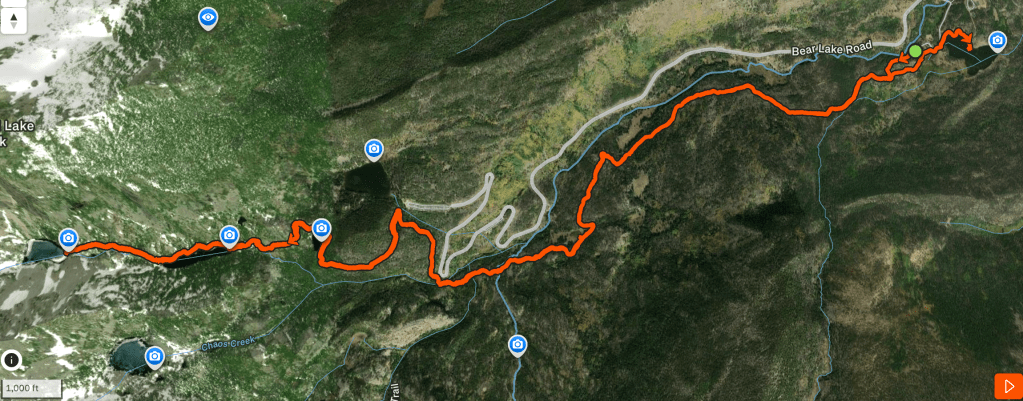 Map showing a route highlighted in orange, with various markers along the path, set against a green and brown landscape representing forested and mountainous terrain.