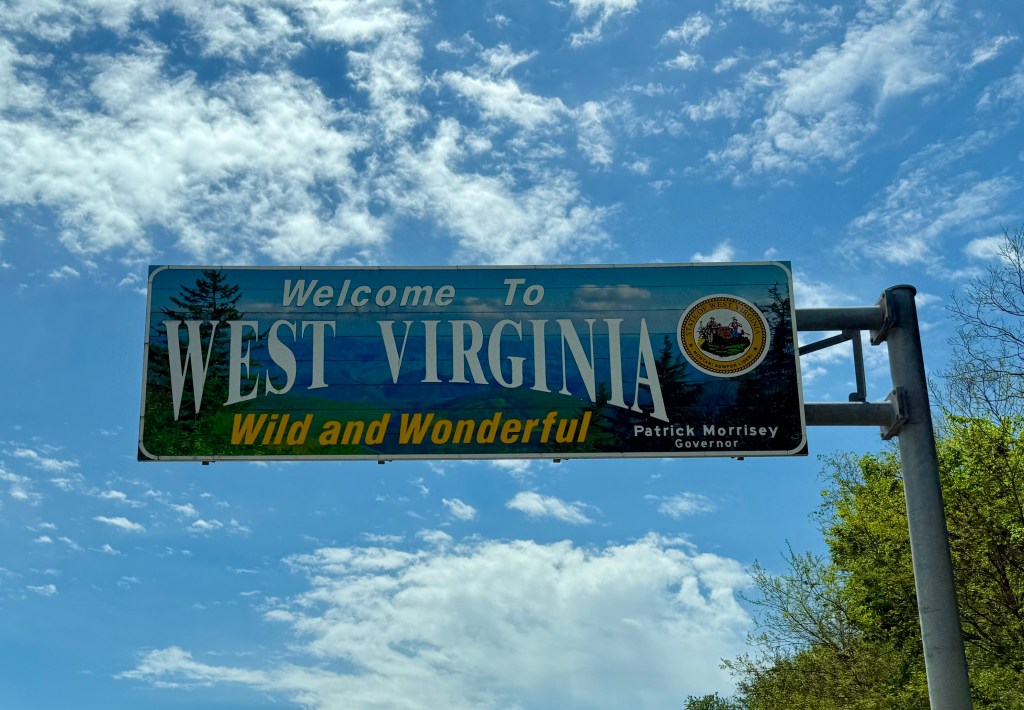 Sign welcoming visitors to West Virginia, featuring the phrase 'Wild and Wonderful' and stating the name of the governor.
