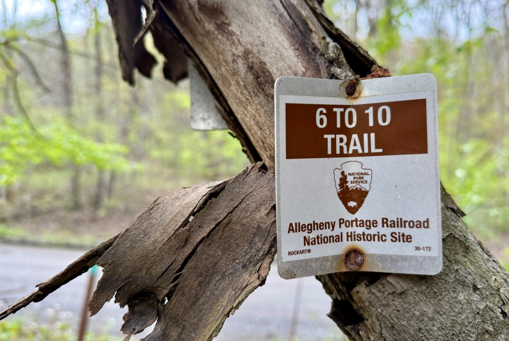 Trail sign for the 6 to 10 Trail at the Allegheny Portage Railroad National Historic Site, attached to a tree with peeling bark.