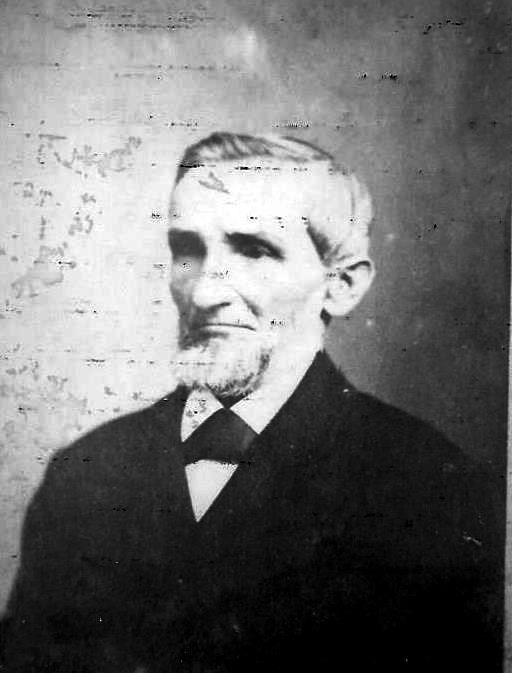 Black and white portrait of an elderly man with a beard, wearing a suit and tie.